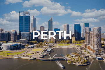 Aerial view of Perth skyline with modern skyscrapers, lush green spaces, and a waterfront. Under the clear blue skies, 'PERTH' is prominently displayed in the center, symbolising opportunities like a business for sale amid this scenic urban backdrop.